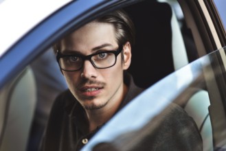Enjoy the drive. Image of young handsome guy sitting in car