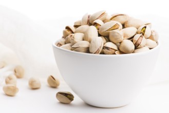Bowl of roasted pistachios on a white background