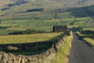 A black barn on the side of a rural road in the Peak District between Rookhope and Ireshopeburn,