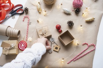 Key to house with keychain on cozy home in gift box with Christmas decor packaging. Pack present