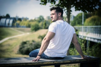 Attractive muscular man in city park in a nice summer day