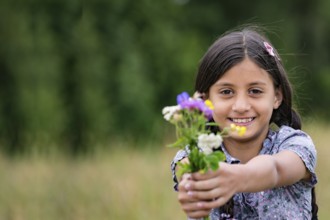 Pretty girl with self-picked bouquet of flowers
