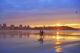 Gijon sunset San Lorenzo beach with surfers in Asturias of spain