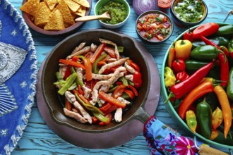 Chicken fajitas in a pan with sauces chili and sides Mexican food