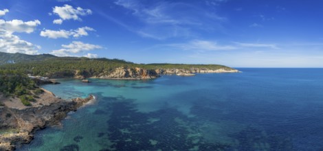 Aerial view the green and rugged hilly coast of northern Ibiza with the turquoise waters of Cala