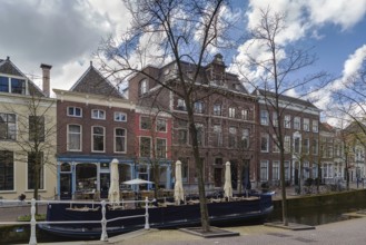 View of Delft canal with historic houses and boat, Netherlands