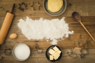 Collection of ingredients and utensils for baking Christmas biscuits with flour as text space in
