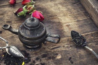 Stylish spoons with variety of tea on vintage wooden board
