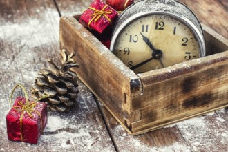 Outdated watch in wooden box on the background of Christmas decorations and pine cones