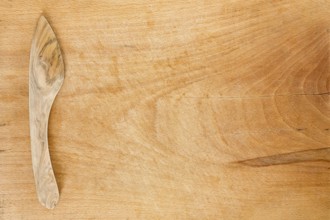 Wooden knife on a wooden background. Studio shot. Kitchen utensil