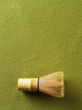 Powdered green tea Matcha background and bamboo whisk Chasen. Copy space for text or design.