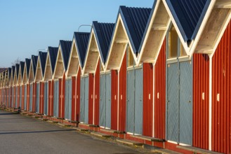 Long row of small, red storage houses with blue doors