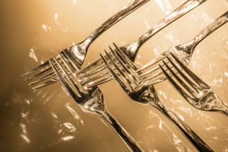 Fork, spoon and knife with reflections and light effects