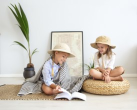 Two little girls are playing at home to travelers wearing vintage style clothes. Childhood,