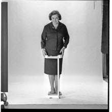 Woman in the 1960s. She is standing and weighs herself on a scale. Sweden november 1965
