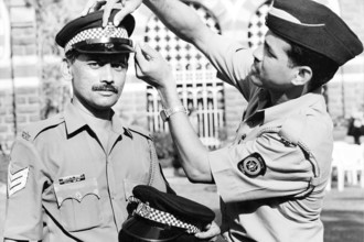 Police constable adjusts the cap of Police Officer, Mumbai, Maharashtra, India, Asia, 1900s, Asia