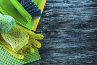 Dustpan brush sponges safety gloves dishcloth on wooden board