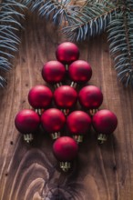 Red christmas baubles in the form of fir tree and branches firtree vintage wood board