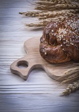 Chopping board wheat rye ears bread stick on wooden background food and drink concept