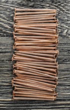 Stack of copper nails on wooden board
