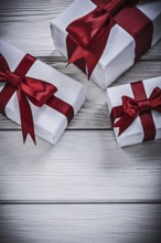 Present boxes with tied ribbons on wooden board holidays concept