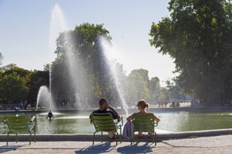 Paris, France, September 3, 2018: A man and a woman are resting by the pond in the Tuileries garden