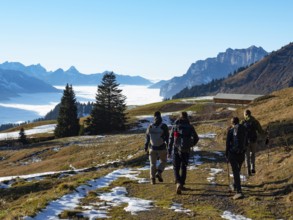 Autumn scenery with four hikers in the Swiss Alps. Very beautiful weather in the height, a big sea