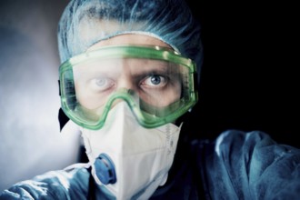 Close-up of a medical professional in protective gear with an intense gaze