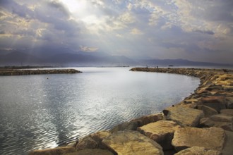 Solar beams above a lagoon in Red sea, fenced by an artificial pier