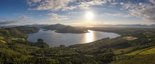 An aerial panorama of Caragh Lake in County Kerry with the sun setting over the lake