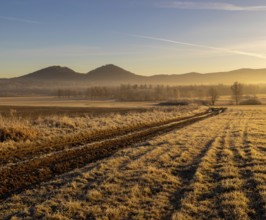 Sunrise in Rudawy Janowickie. View of Rudawy Janowickie. Frozen field at sunrise