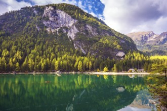 Magnificent lake Lago di Braies. Emerald expanse of water reflects the surrounding forest and