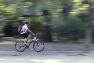 Sofia, Bulgaria - 20 August 2017 - Young man rides a bike in the park. Slow motion with blurred