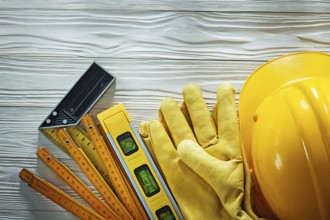 Protective gloves try square construction level wooden meter hard hat on wood board