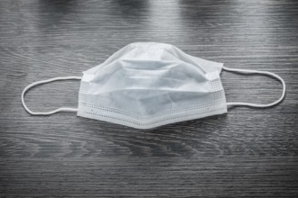 Sterile flu mask on vintage wooden board