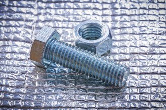 Stainless bolt and screw nut on metal background construction concept