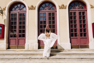 Sibenik, Croatia - 05.06.17: Bride in a white dress fluttering in the wind stands in front of high