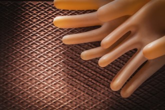 Protective insulating gloves on dielectric rubber mat