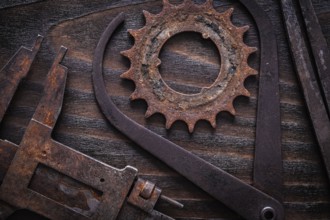 Set of rusty measuring calipers with cog- wheel on vintage dark wooden surface construction concept
