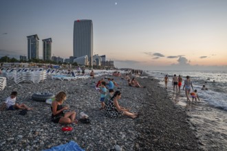 BATUMI, GEORGIA - AUGUST 22, 2023: People on the stone beach