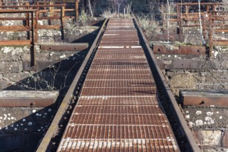 Rusted metal walkway in an industrial setting with grid pattern