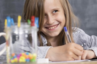 The girl solves the task given in the classroom. The schoolgirl diligently writes in a notebook
