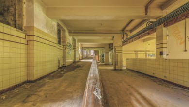 Long abandoned corridor with tiled walls and graffiti, industrial decay, Preventorium Dolhain, Lost