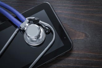 Close up of stethoscope and pad on vintage wooden background medicine concept