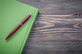 Notepad brio pen on wooden board copy space