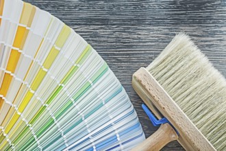 Horizontal view of color palette fan paintbrush on wooden board