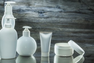 Higiene products white plasic pump dispensers tube and jar cream on vintage wooden background