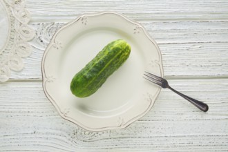 Cucumber full in white plate minimalist concept of raw vegetarian food
