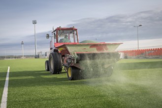 Pouring infill granules in to a football pitch with artificial grass in Lubin, Poland, Europe