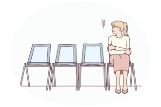 Anxious young woman sit on chair in corridor waiting or appointment. Stressed female feel worried